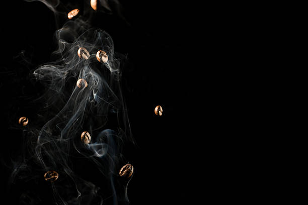 Conceptual image of coffee beans falling down trough the smoke
